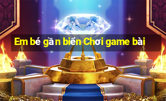 Em bé gần biển Chơi game bài